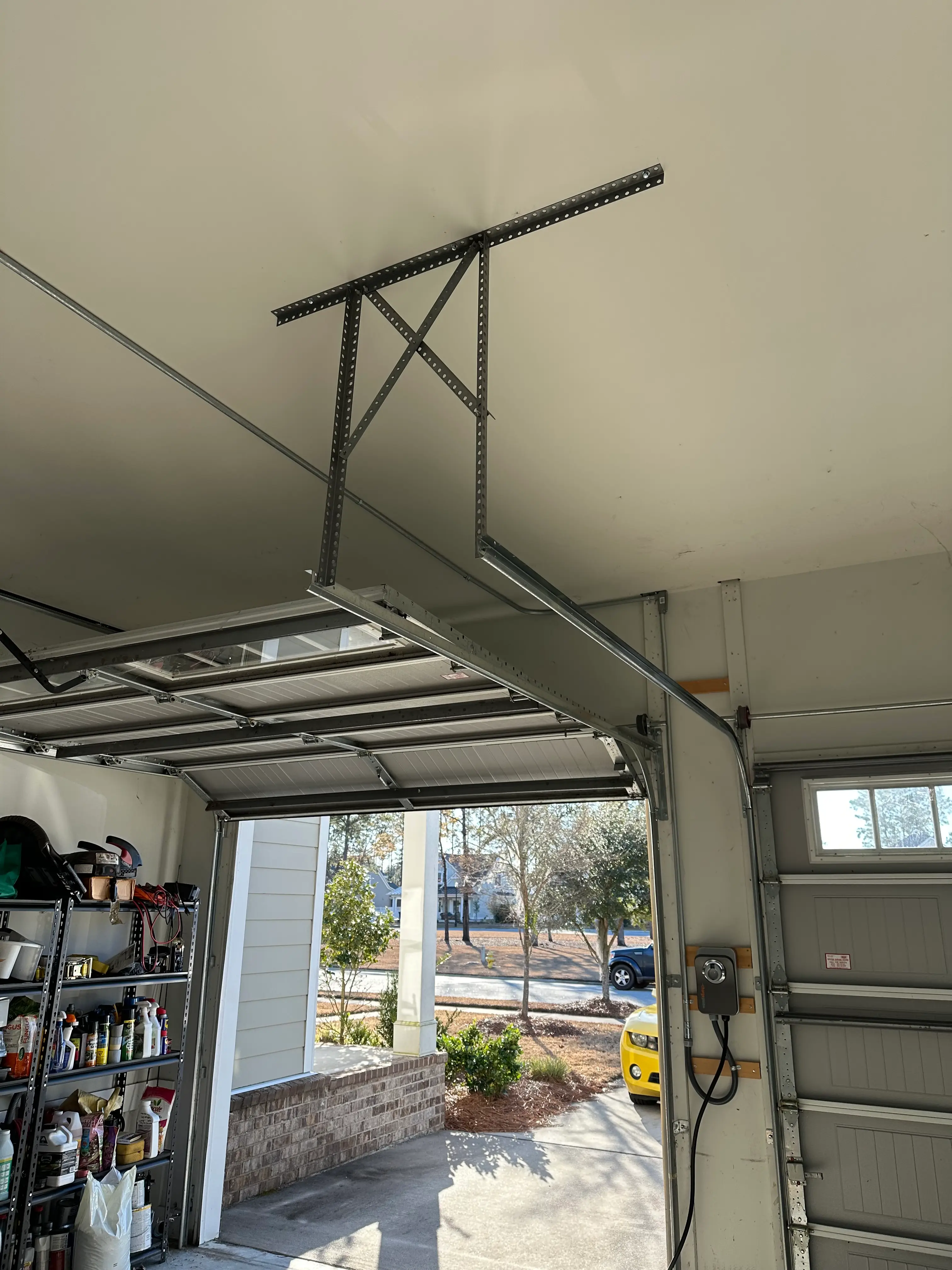Garage interior showing metal conduit and wall-mounted electrical equipment beside an overhead door